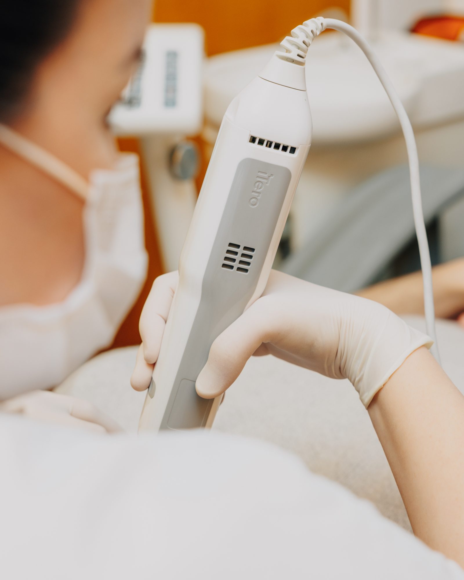 Behandlerin scannt die Zähne mit dem Intraoralscanner