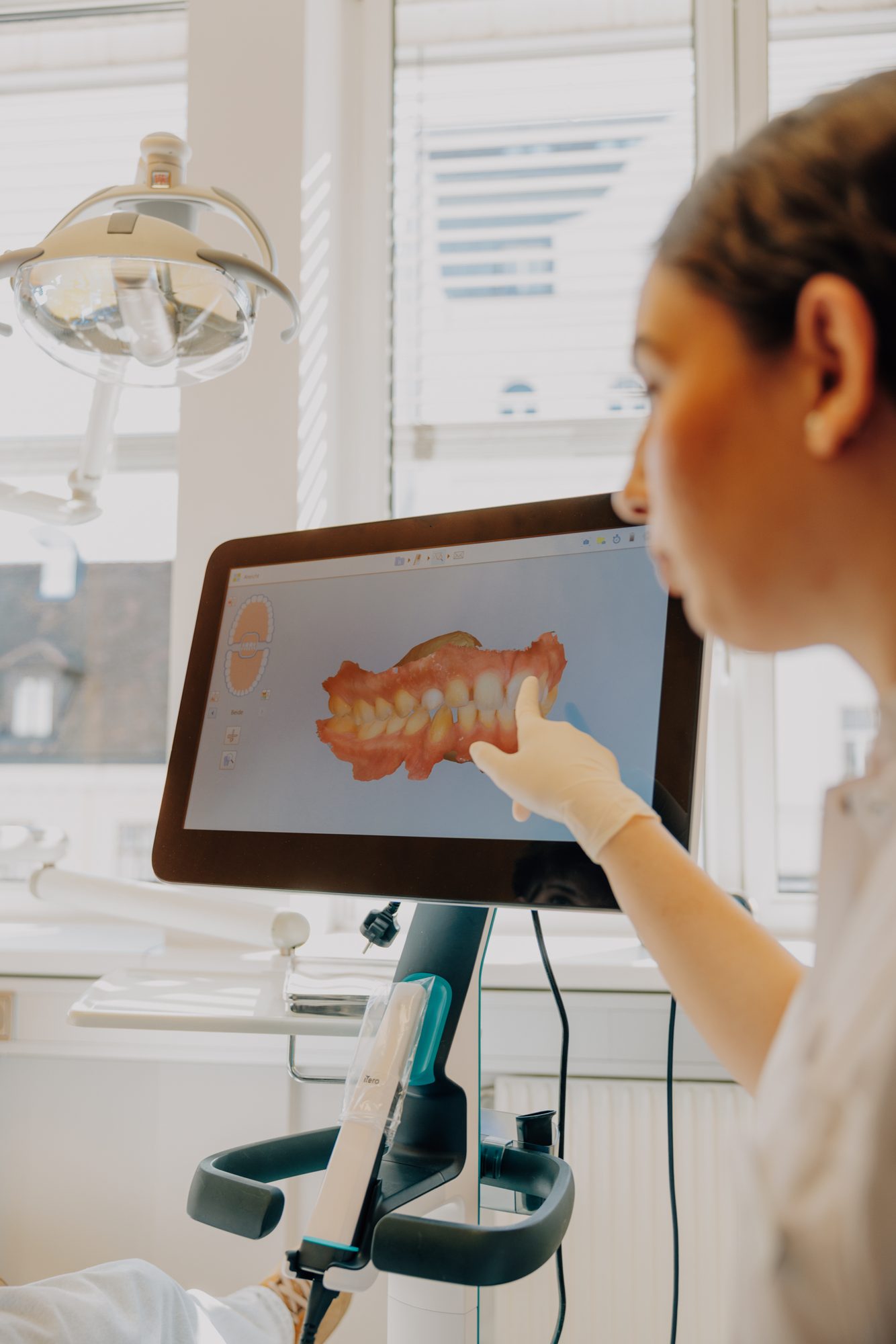 Assistentin zeigt den digitalen 3D-Zahnscan am Bildschirm
